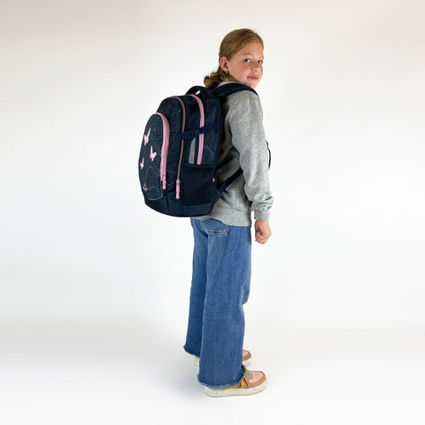 Mädchen trägt Mädchen Schulrucksack Fame 2.0 Glow in the Dark 3.0 von Walker auf dem Rücken